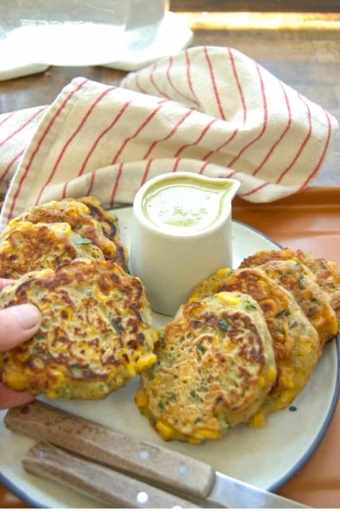 A plate full of sweet corn fritters made by using leftover corn.