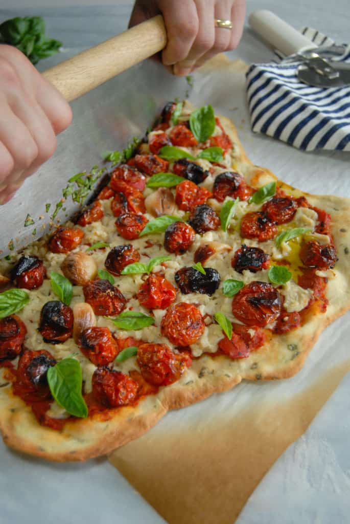 homemade rustic vegan cheese pizza being cut
