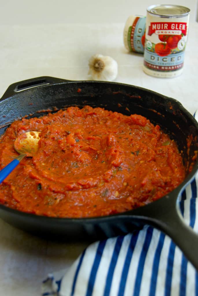 A pan with fire roasted tomato sauce cooking
