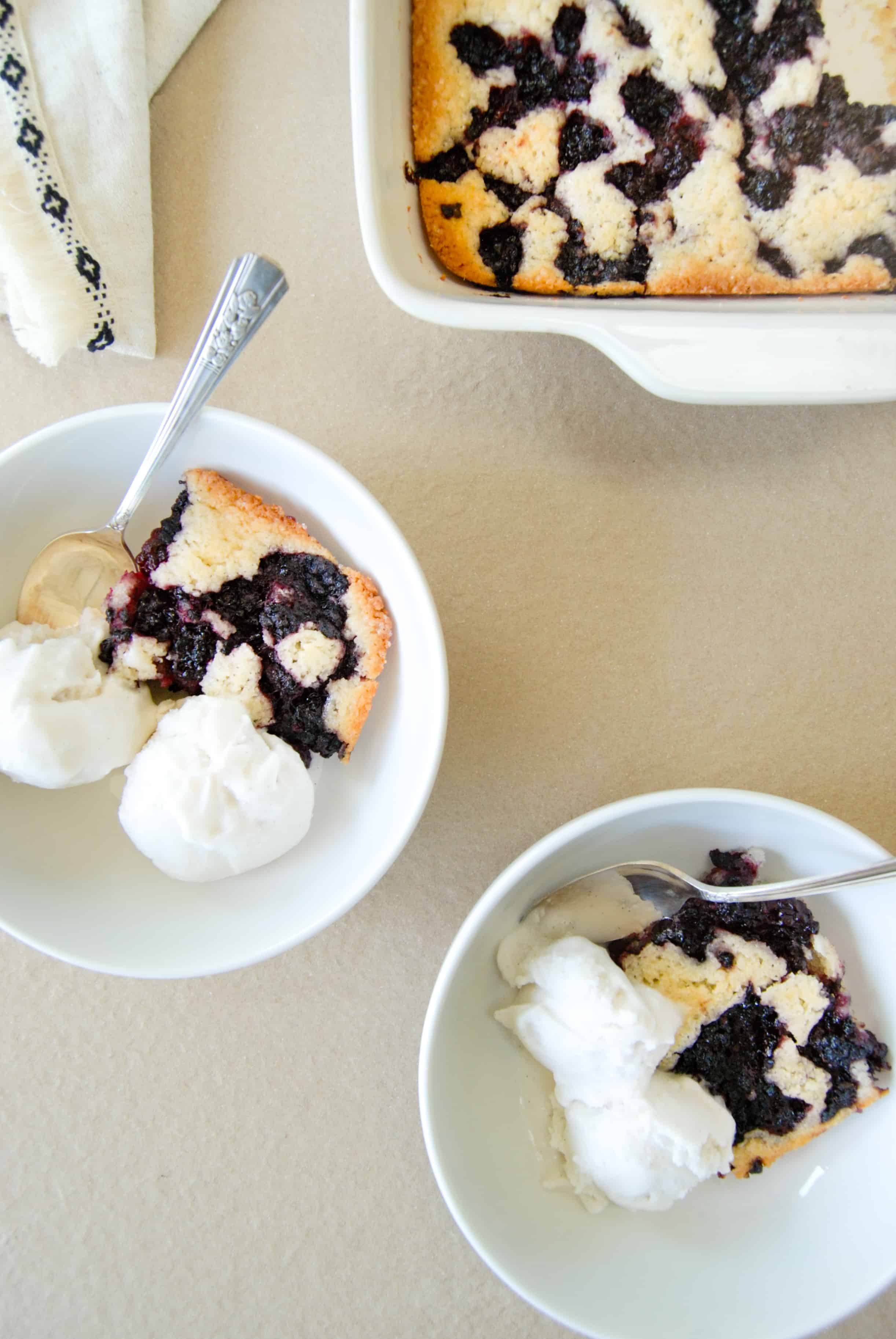 vegan black berry cobbler in  two bowls with ice cream