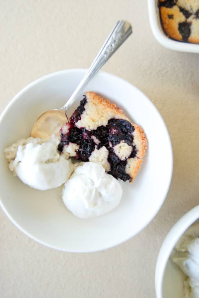 a slice of vegan blackberry cobbler in a bowl with ice cream