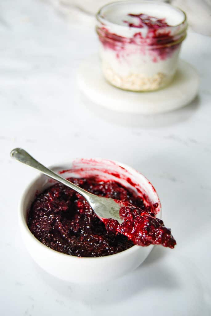 a dish of keto blackberry jam on a marble countertop.