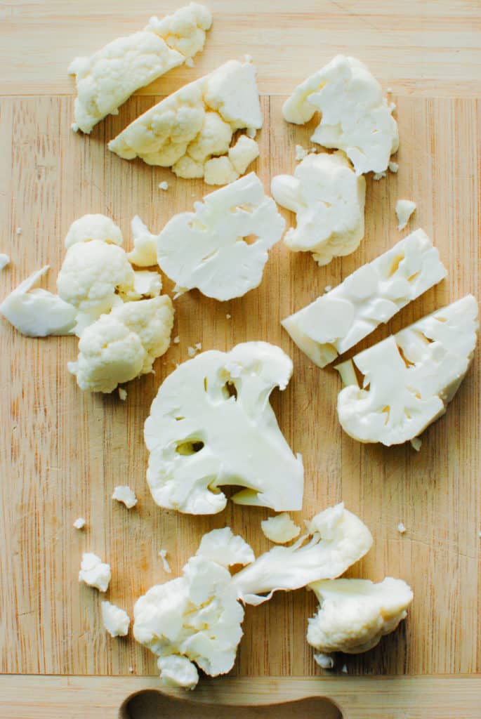 cauliflower florets on a cutting board
