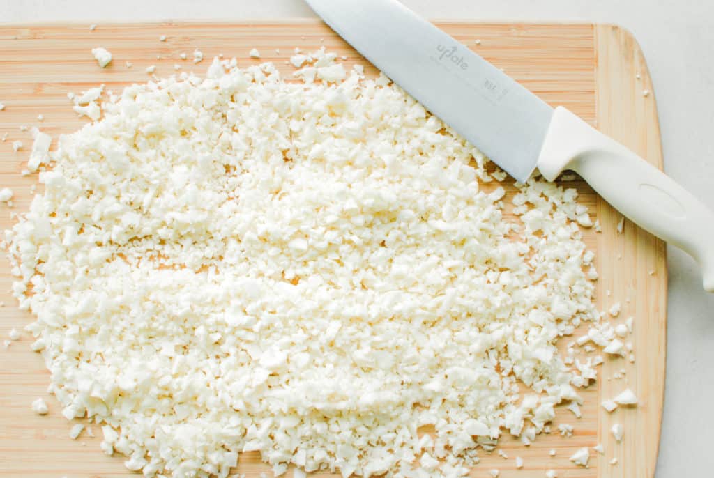 cauliflower rice on a cutting board made with no food processor.
