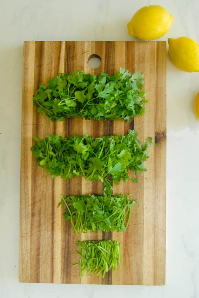 fresh cilantro on a cutting board with lemons