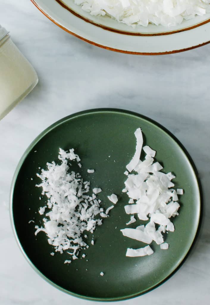 Two types of dried coconut on a plate: coconut shreds and coconut chips
