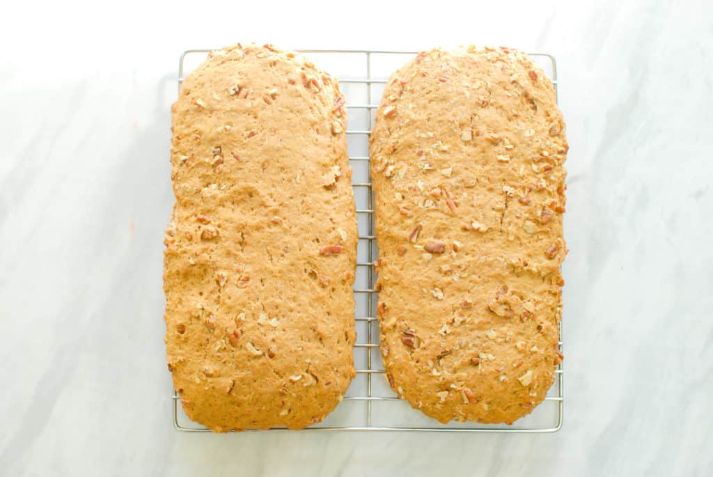 Two logs of biscotti cooling on a wire rack.