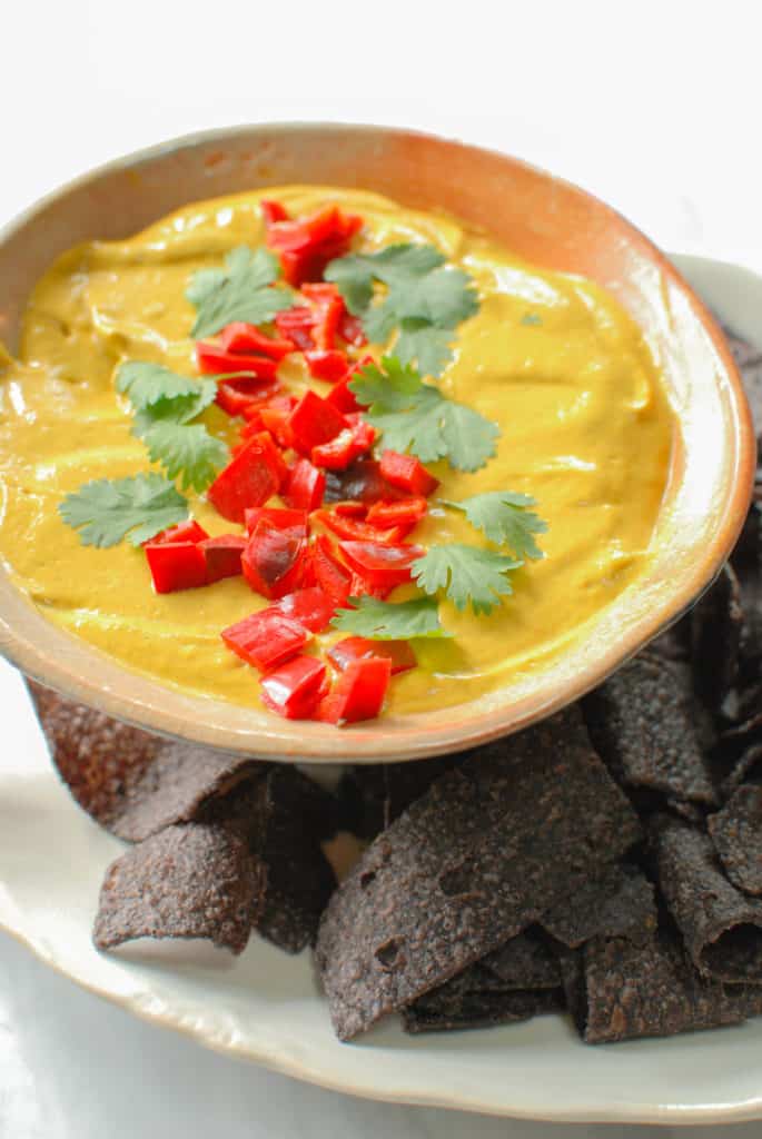 a bowl of savory pumpkin dip with chips next to it.