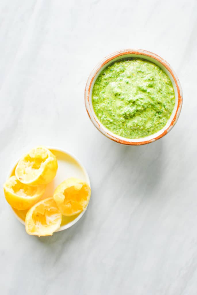 A bowl of homemade meyer lemon pesto and a bowl of squeezed meyer lemons that were juiced to make it!