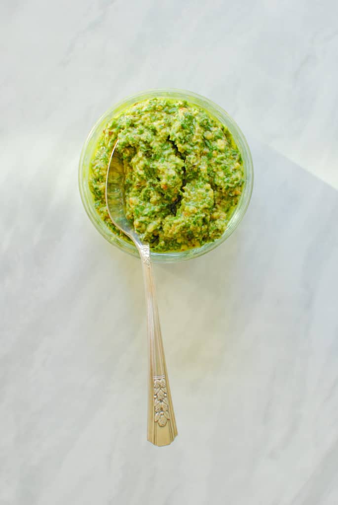 A spoonful of fresh homemade vegan walnut pesto on the counter.