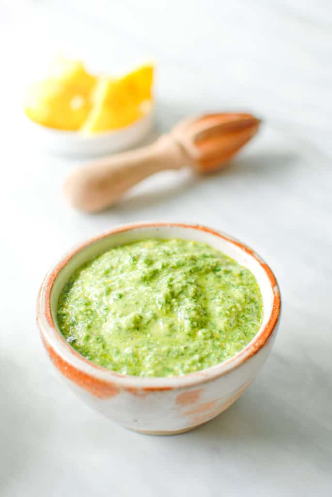 A bowl of meyer lemon pesto sauce on the counter.