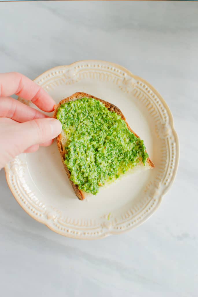 A piece of toast covered in willamette transplant's nut free pesto.