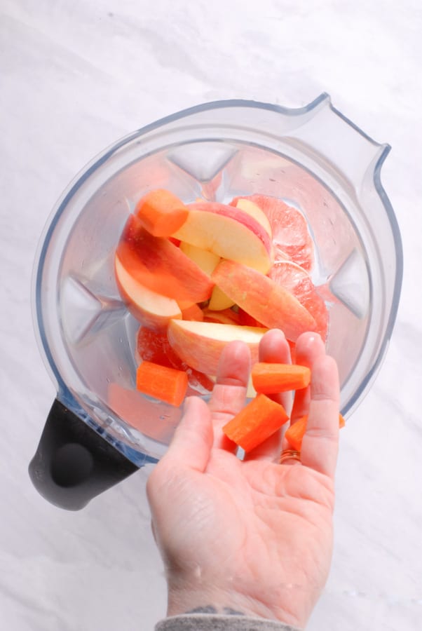 adding ingredients to a blender for grapefruit juice