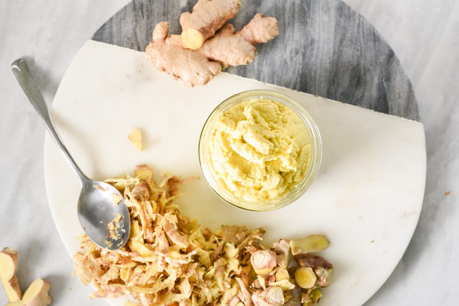 peeled ginger root next to DIY ginger paste in a jar