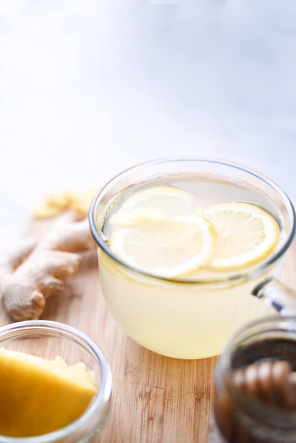 a cup of lemon tea on a cutting board