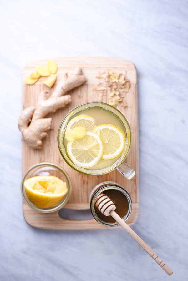ingredients to make lemon ginger honey tea on a cutting board