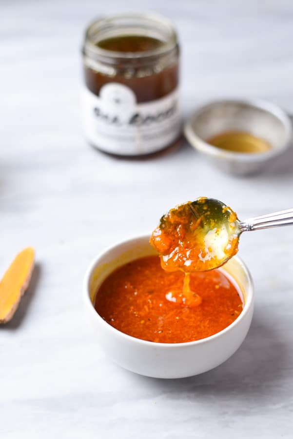 Close up shot of fresh turmeric honey dripping off a spoon