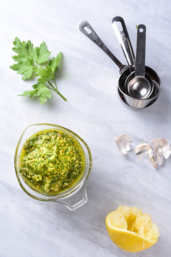 ingredients to make pesto with parsley laid out on the counter