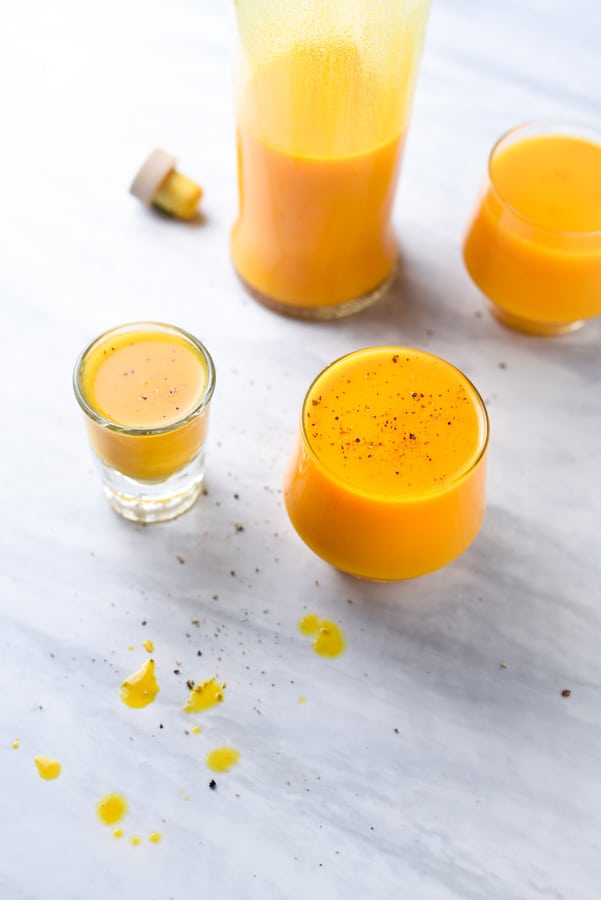 fresh turmeric juice shots on a marble counter