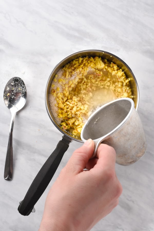 a hand pouring water into a pot