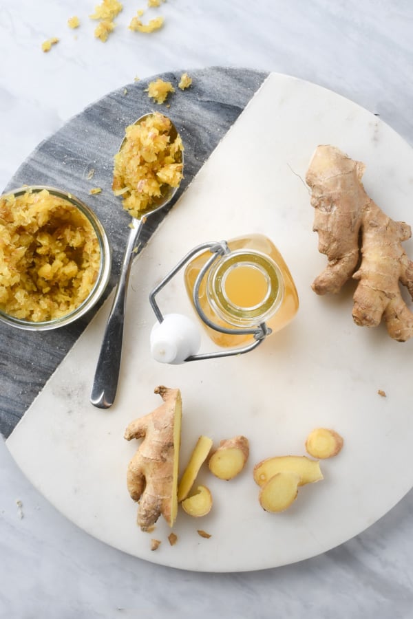 ginger syrup, candied ginger, and fresh ginger on a counter 