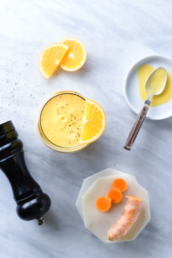 Overshot of orange peels and a turmeric mango smoothie