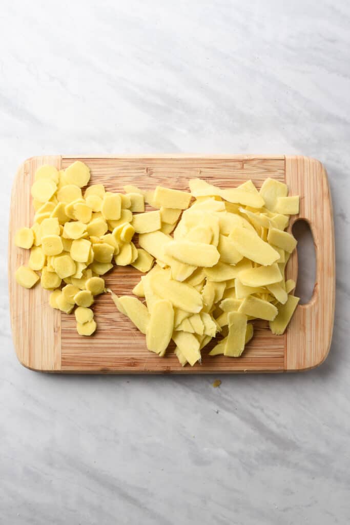 fresh ginger slices and circles on a cutting board.