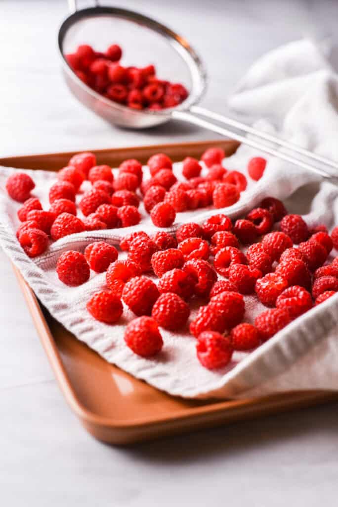 fresh raspberries drying on a kitchen towel