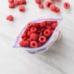 close up on a plastic bag full of frozen raspberries