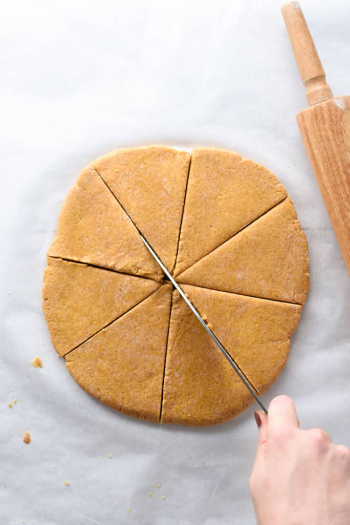 Pumpkin scone dough being rolled into a disc for shaping