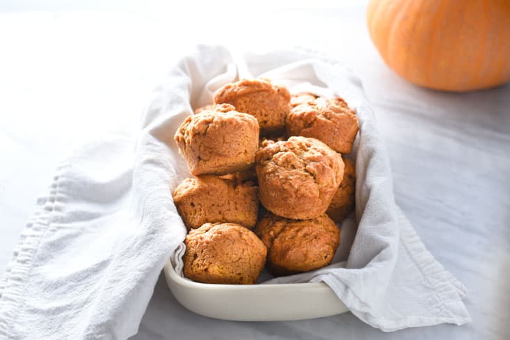 Vegan pumpkin muffins in a towel on the counter.