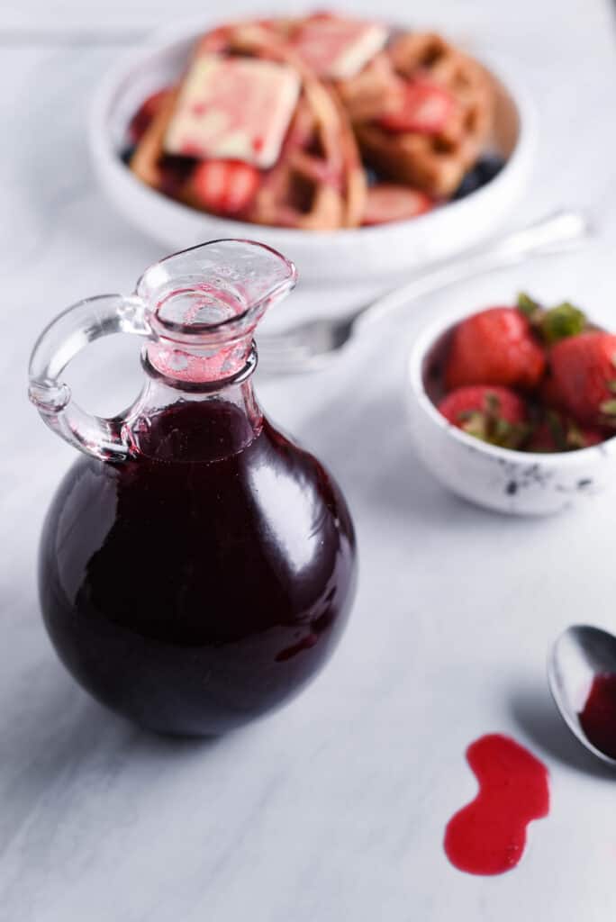 Raspberry simple syrup in a container.