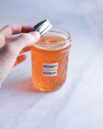 a jar of homemade honey syrup on the counter