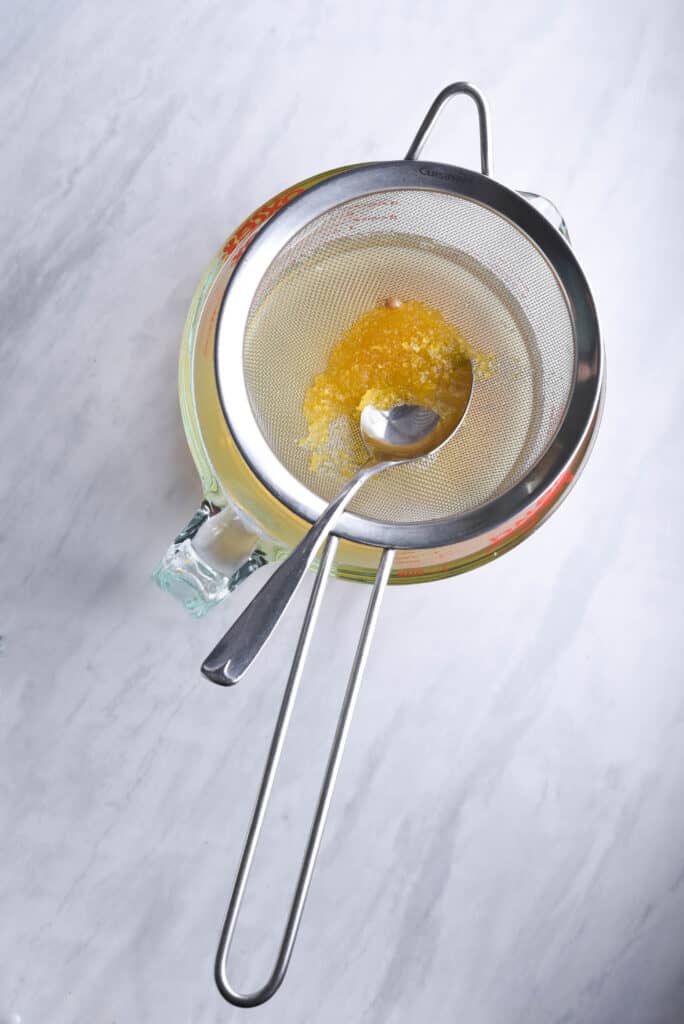 Lemon syrup in a strainer