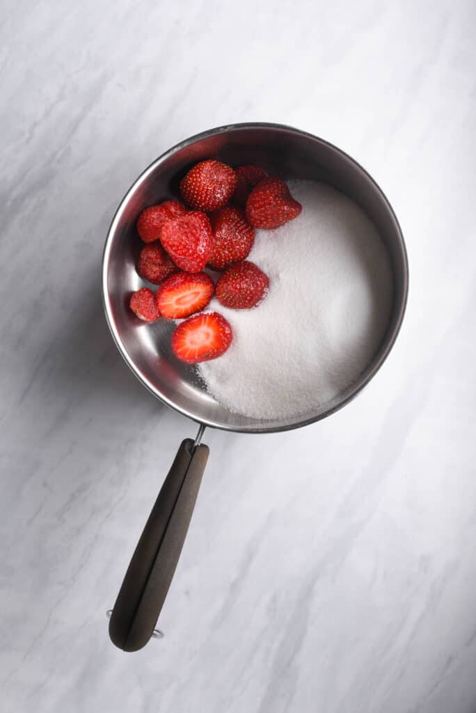 Strawberries and sugar in a pot to make syrup