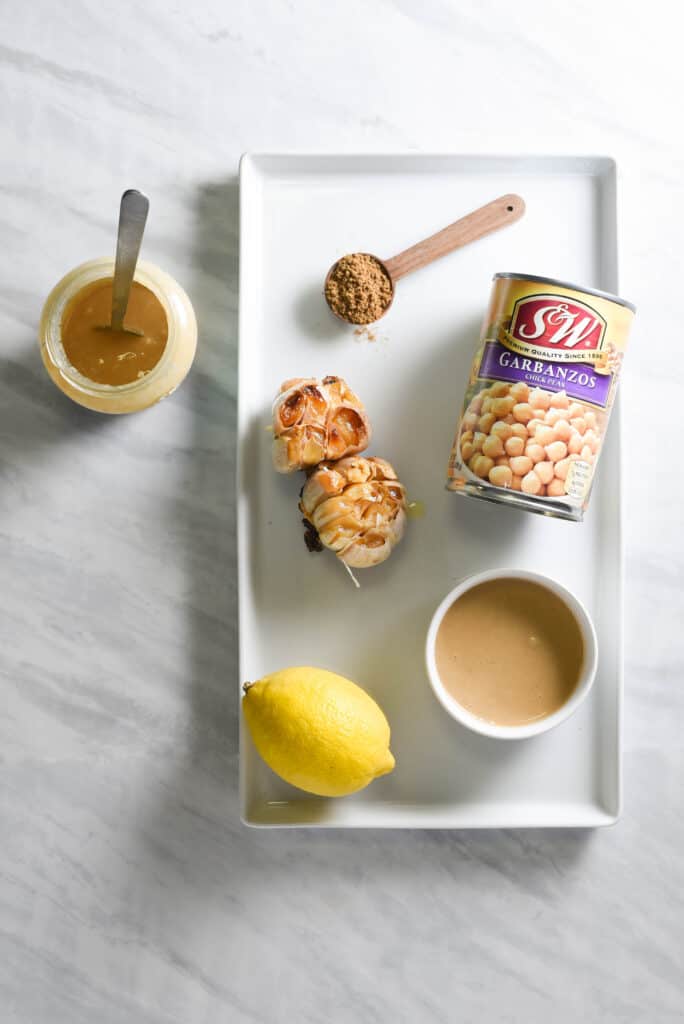 ingredients to make roasted garlic hummus on a tray