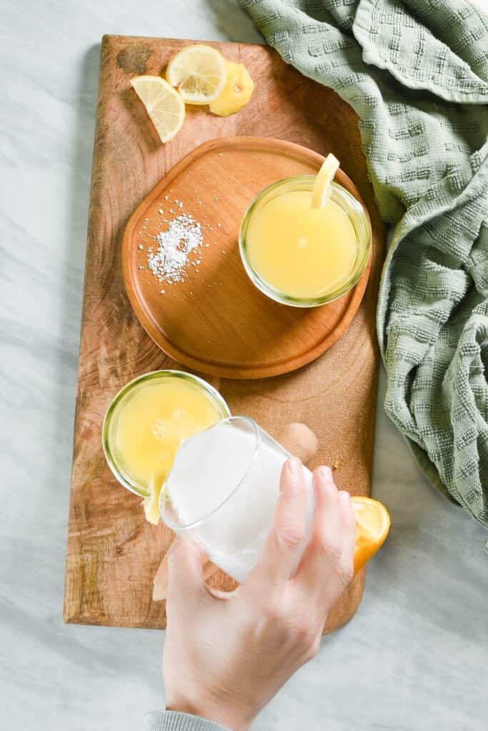 a hand pouring coconut cream into an adrenal cocktail