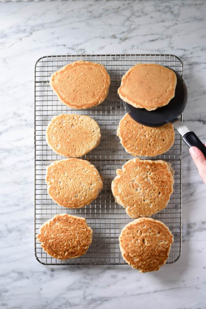 Vegan pancakes cooling on a wire rack to save for quick weekday breakfasts.