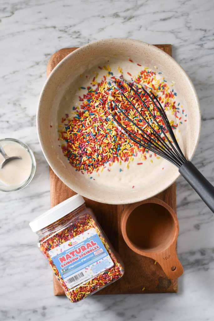 Pancake batter and sprinkles in a mixing bowl.