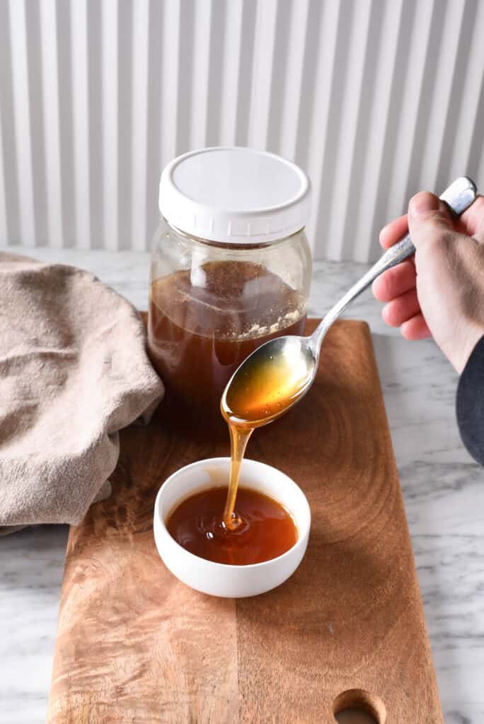 Vegan honey dripping off of a spoon.