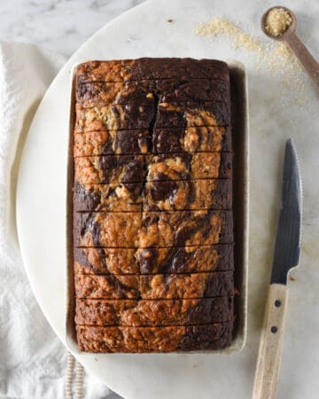 A loaf of homemade marble swirled banana bread on a tray.