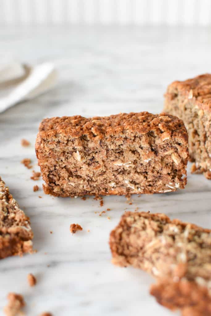 Slices of banana oat bread with scattered crumbs.